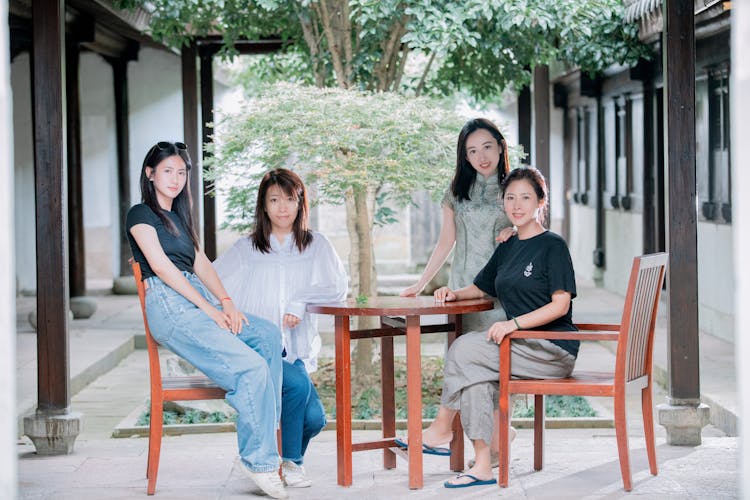 一群朋友坐在内花园旁的桌子旁