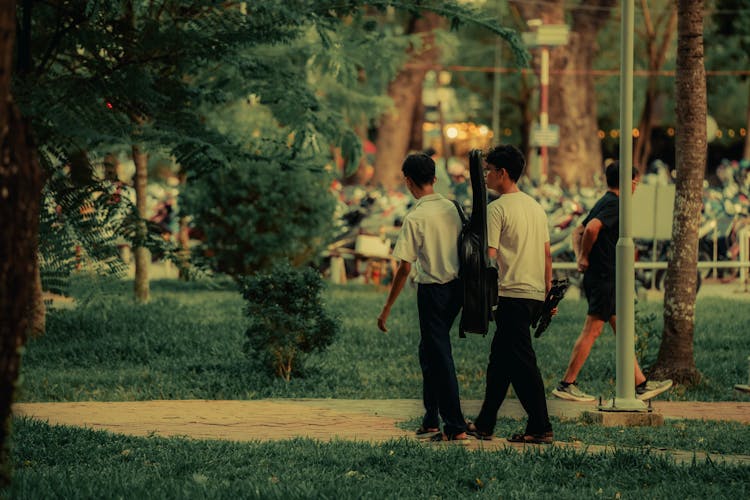 两个男人在公园里拿着乐器散步的坦率照片