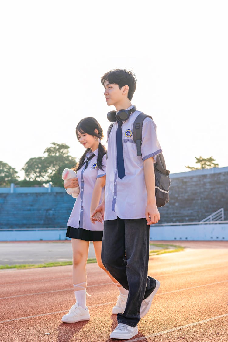 青少年学生在户外运动跑道上行走