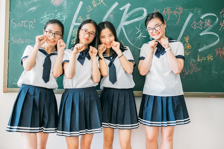 四个学生在教室里嬉闹地摆姿势