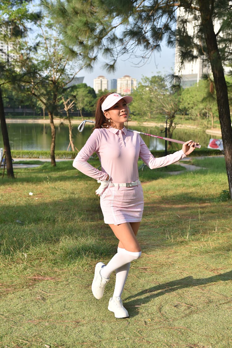 阳光明媚的日子里，年轻女子正在享受高尔夫