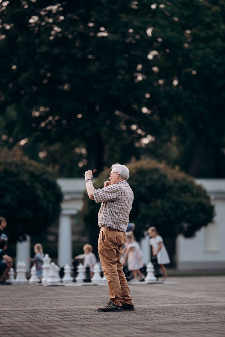 老人在户外拍摄巨型象棋比赛