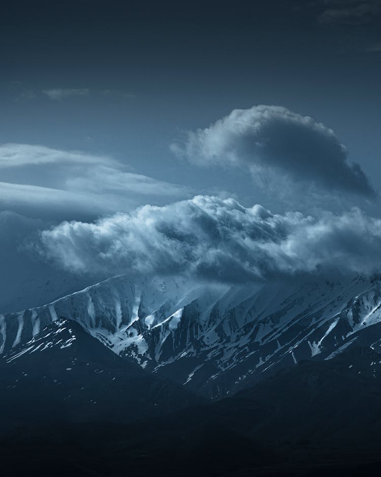 多云天空下戏剧性的雪山
