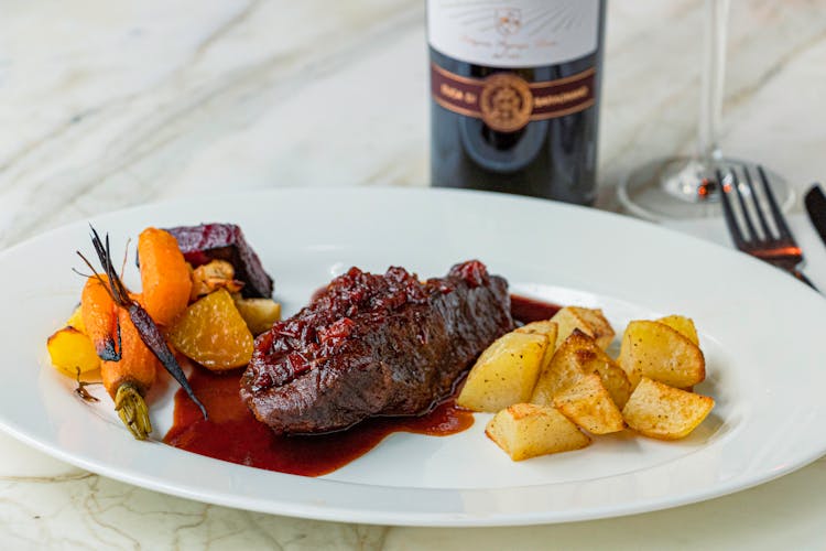 一瓶酒配一盘牛肉、胡萝卜和土豆
