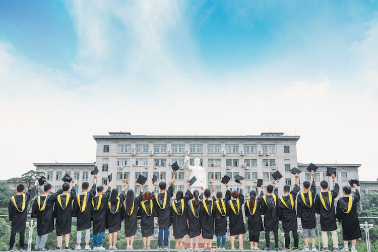 毕业生们戴着帽子在空中庆祝