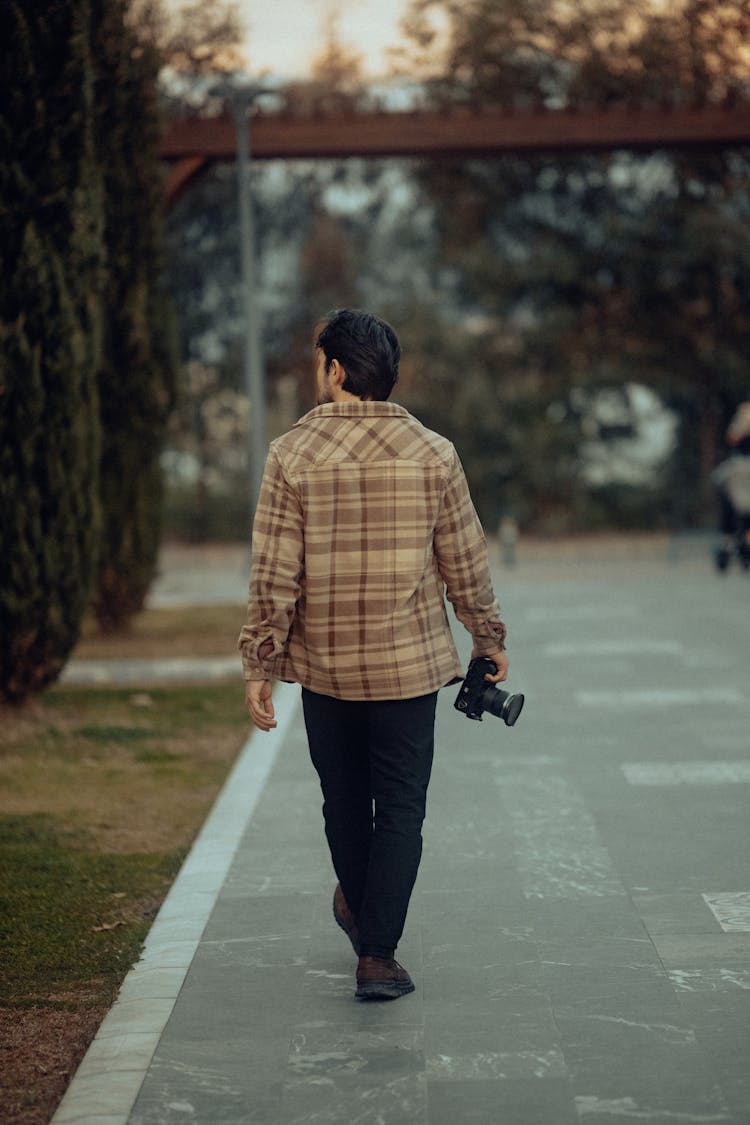穿夹克的男人在公园散步