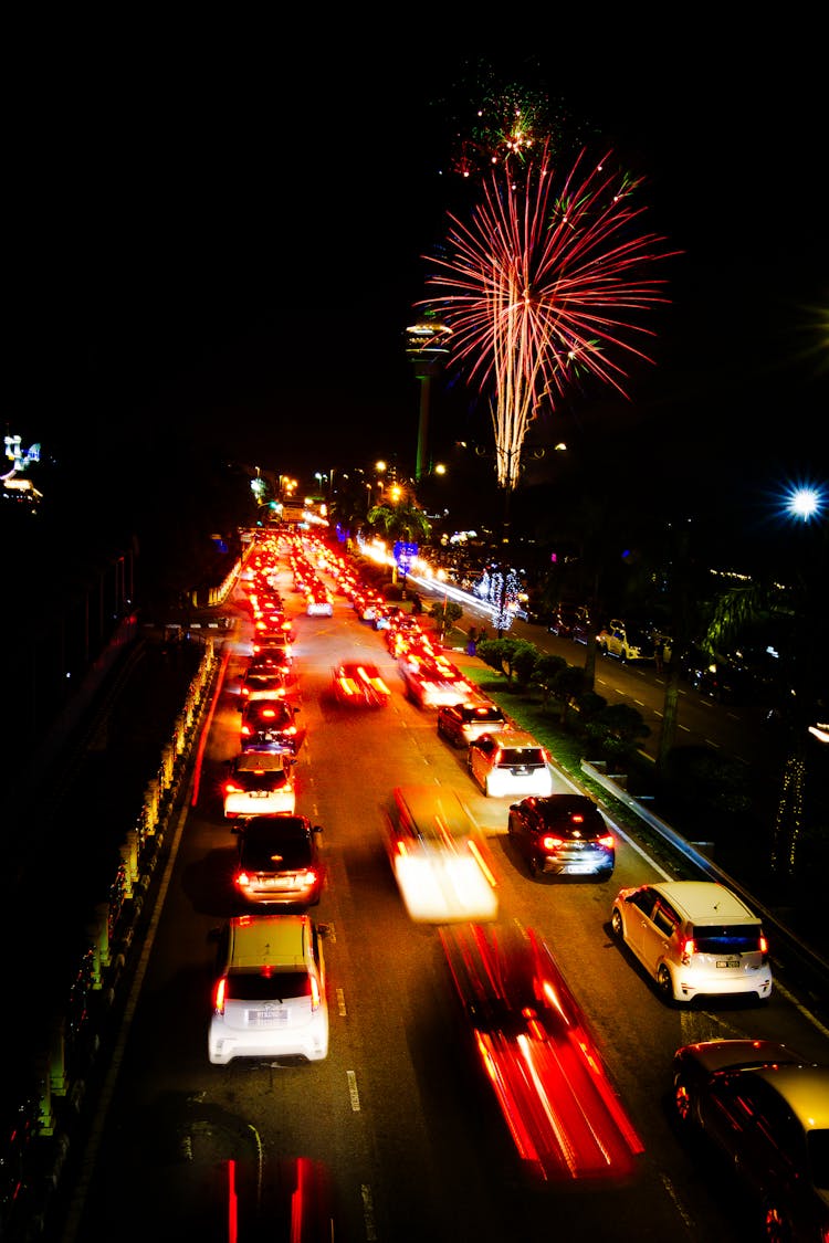 公路上的汽车和夜空下的烟花