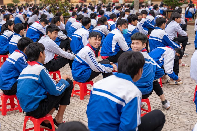 小学生坐在外面的椅子上
