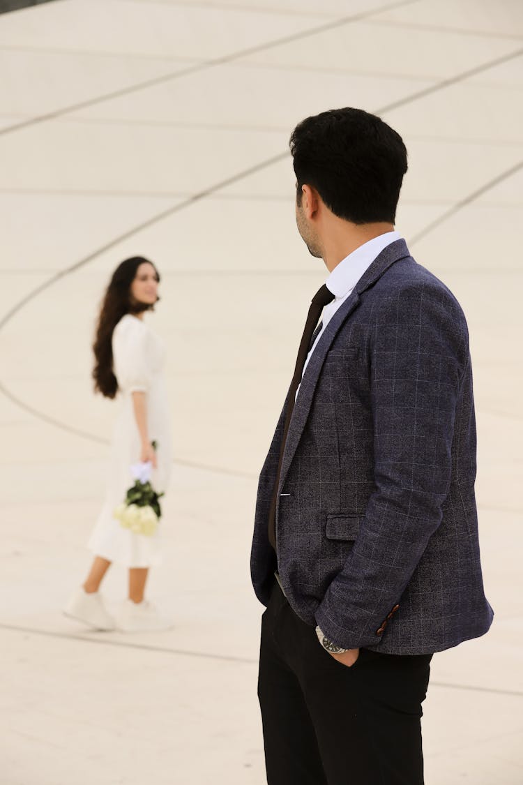穿着得体的男人回头看穿白色连衣裙的女人