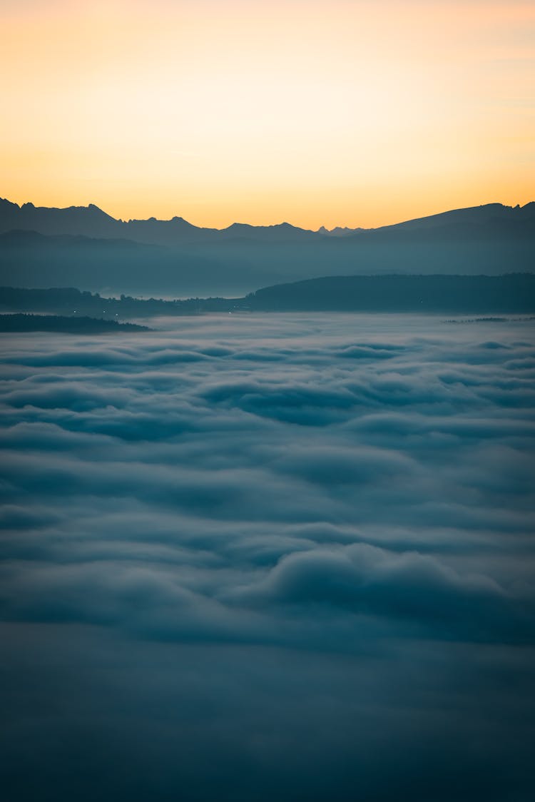 日出时云层之上宁静的山景