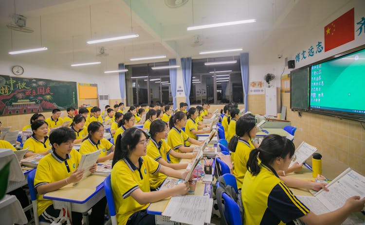 穿着黄色衬衫的学生在教室里学习