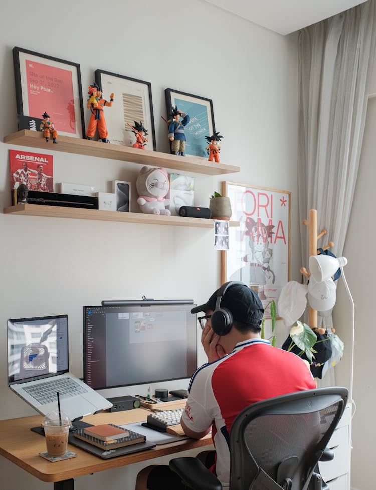 一个男人坐在桌子旁，手里拿着一台电脑