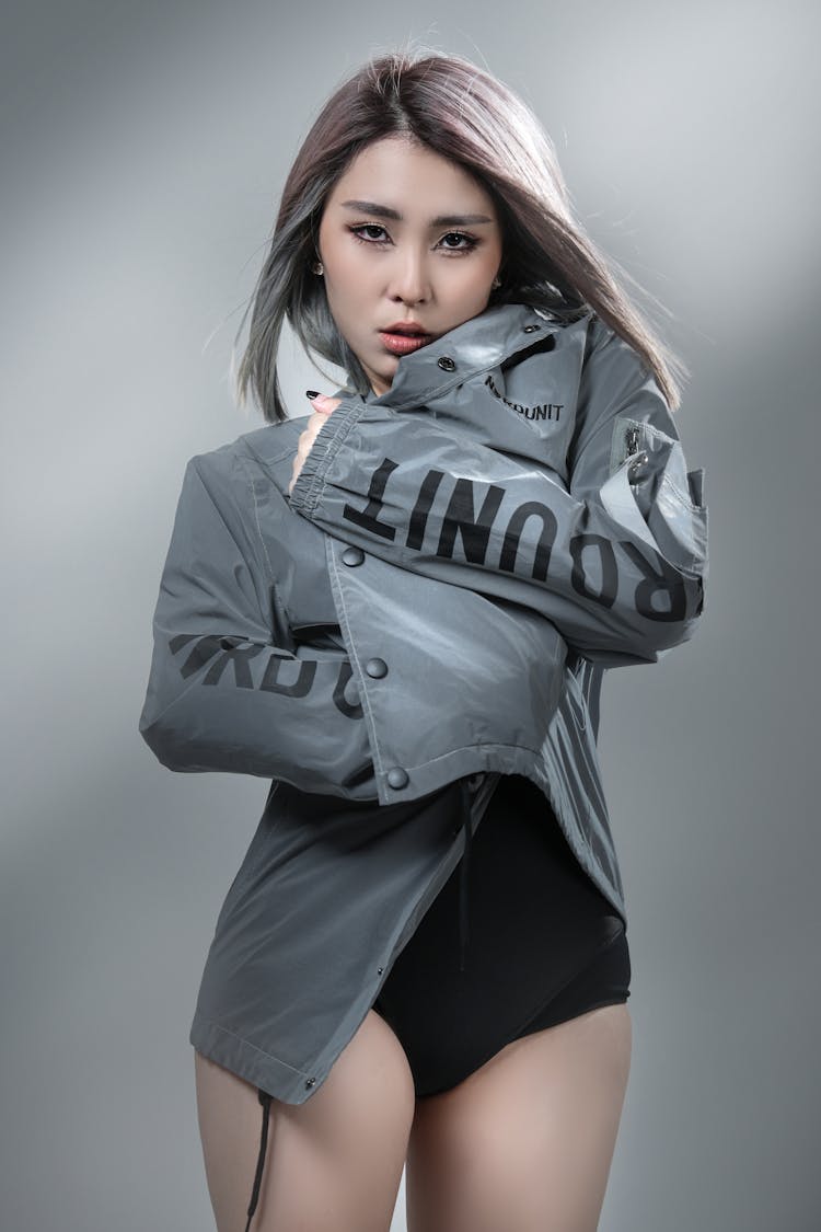 穿着灰色夹克的年轻女子摆姿势